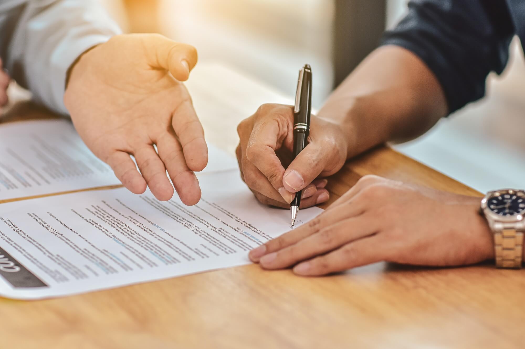 mężczyzna podpisuje akt notarialny u notariusza